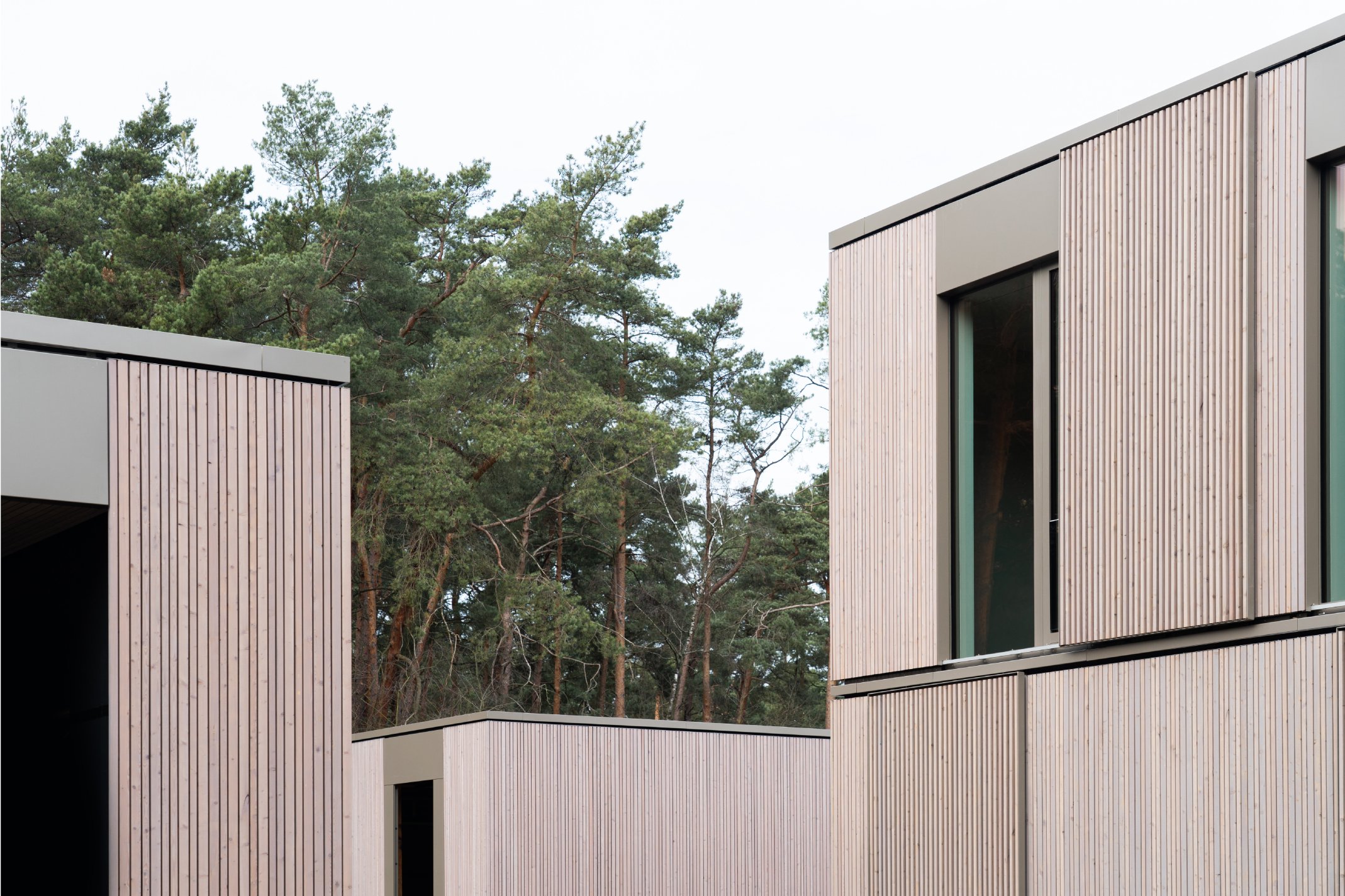 Rhythmisierte Holzfassaden und Schiebeläden der Villa aus vier Gebäuden am Wandlitzsee von Bonauer Bölling Architekten