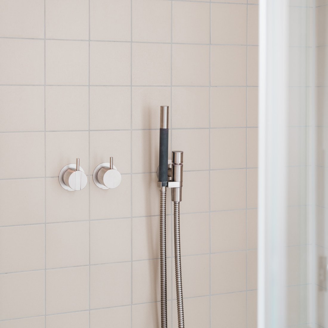 Detail der Dusche mit Fliesen aus Feinstenzeug von Zahna und Armaturen in mattem Edelstahl von Vola