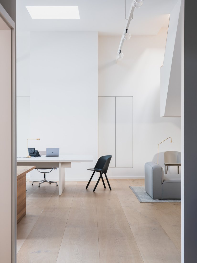 Maßgefertigte Arbeitstische und Einbauschränke, Stühle von Vitra und e15, Teppich von Kvadrat und Sofa von Normann Copenhagen