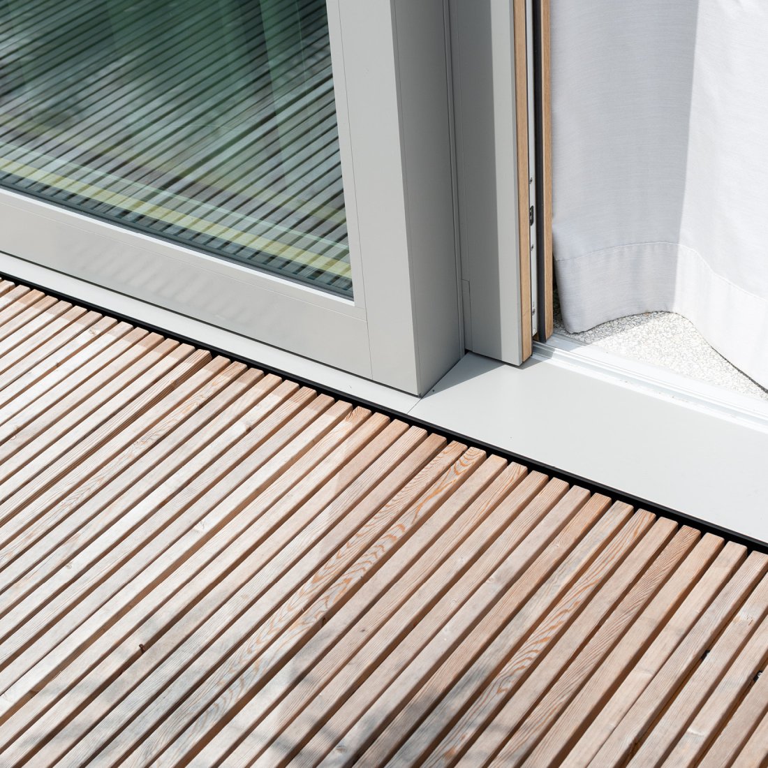 Detailbild Holzterrasse aus Mocopinus Pinutex Terrassenmodulen aus sibirischer Lärche und Hebe-Schiebe Anlage aus Holzaluminium Rahmen