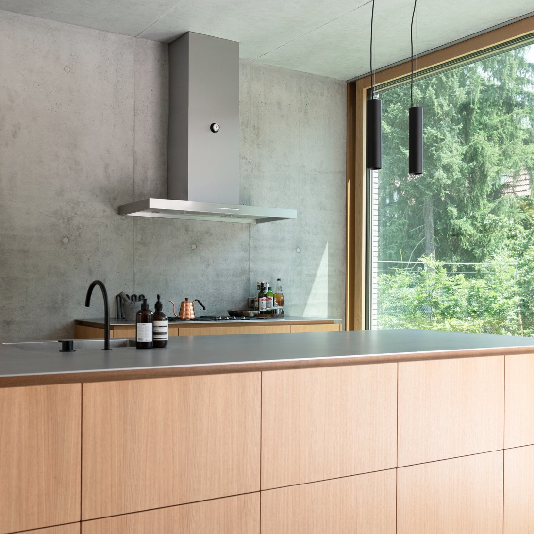 Maßgefertigte Kücheninsel mit echtholzfurnierten Oberflächen in Eiche Natur und matter Edelstahl-Arbeitsplatte Silver Touch von Stadler Edelstahl.