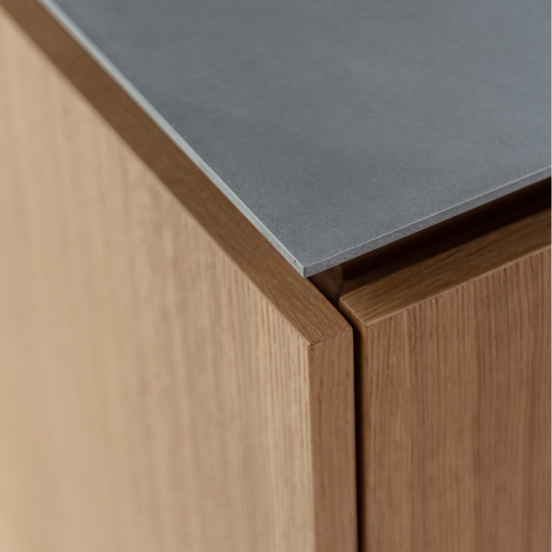 Detail Eckausbildung maßgefertigte Kücheninsel mit echtholzfurnierten Oberflächen in Eiche Natur und matter Edelstahl-Arbeitsplatte Silver Touch von Stadler Edelstahl.