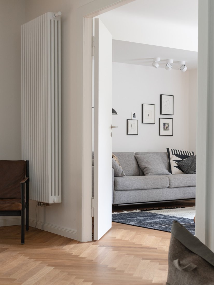 Restaurierter Wohnbereich und Bestandstür mit Fischgrätparkett in Eiche.