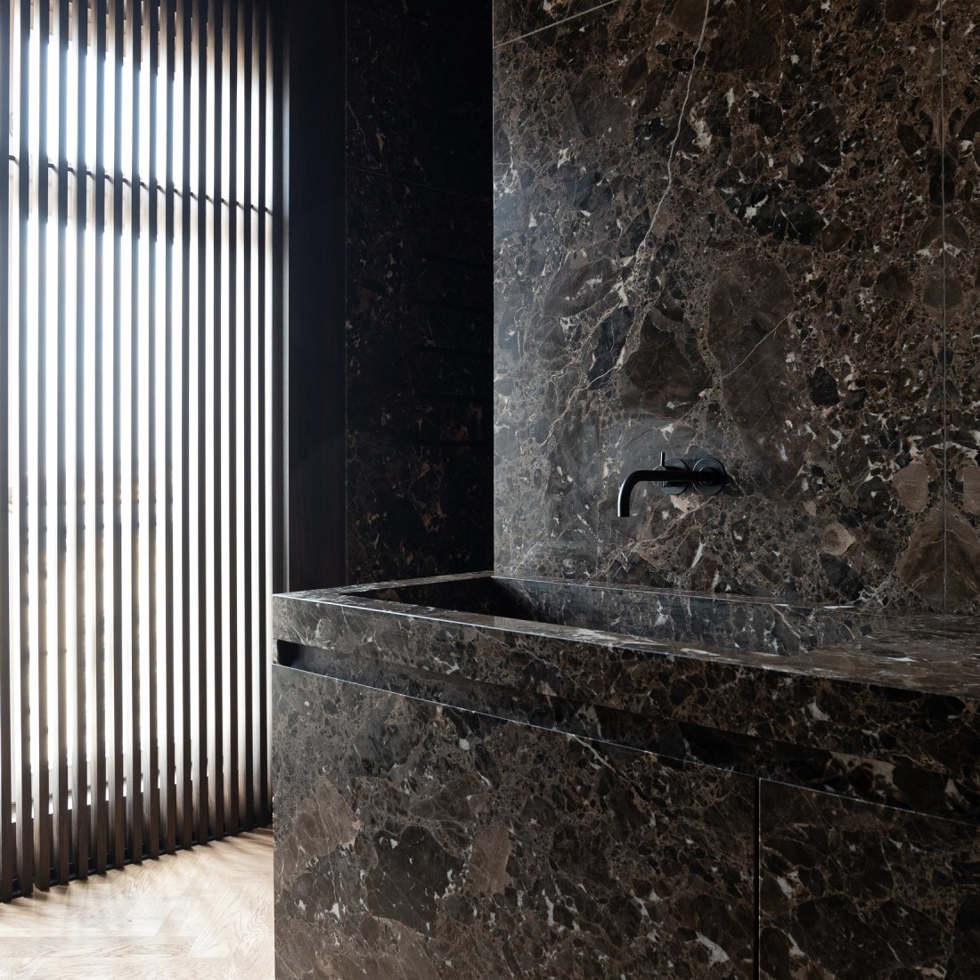 Design Bad mit maßgefertigtem Marmorwaschtisch aus Emperador Marron mit schwarzer Vola Armatur und Holzscreen aus Räuchereiche