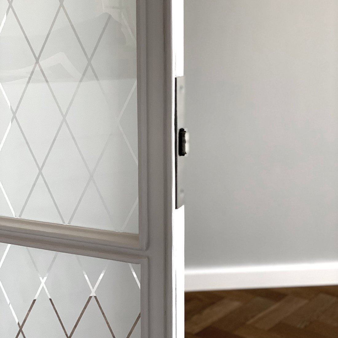 Restaurierte Bestandstür mit Glasfüllung und hochwertig aufgearbeiteter Eichenparkett