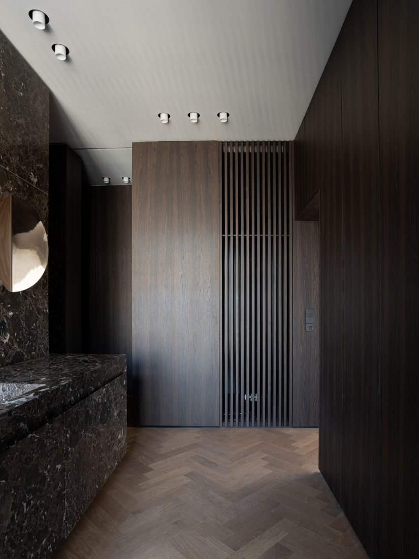 Masterbad mit maßgefertigten Einbauschränken aus Räuchereiche und Marmorwaschtisch aus Emperador Marron mit schwarzer Vola Armatur