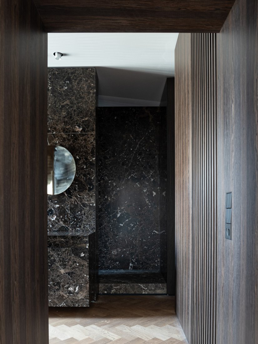 Masterbad mit maßgefertigten Einbauschränken aus Räuchereiche und Marmorwaschtisch aus Emperador Marron