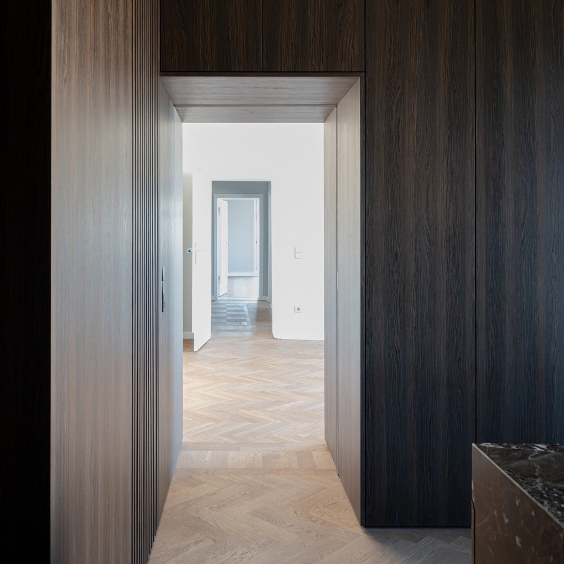 Maßgefertigte Einbauschränke mit echholzfurnierter Oberfläche in Räuchereiche mit integrierter Schiebetür.