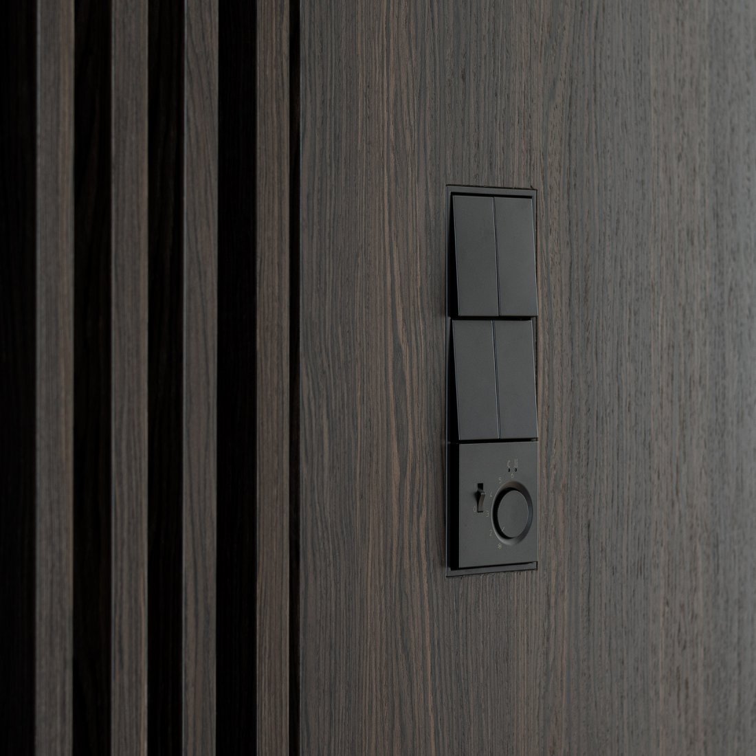 Maßgefertigter Holzscreen und Wandpaneel in Räuchereiche mit flächenbündig integriertem Schaltersystem Jung LS ZERO