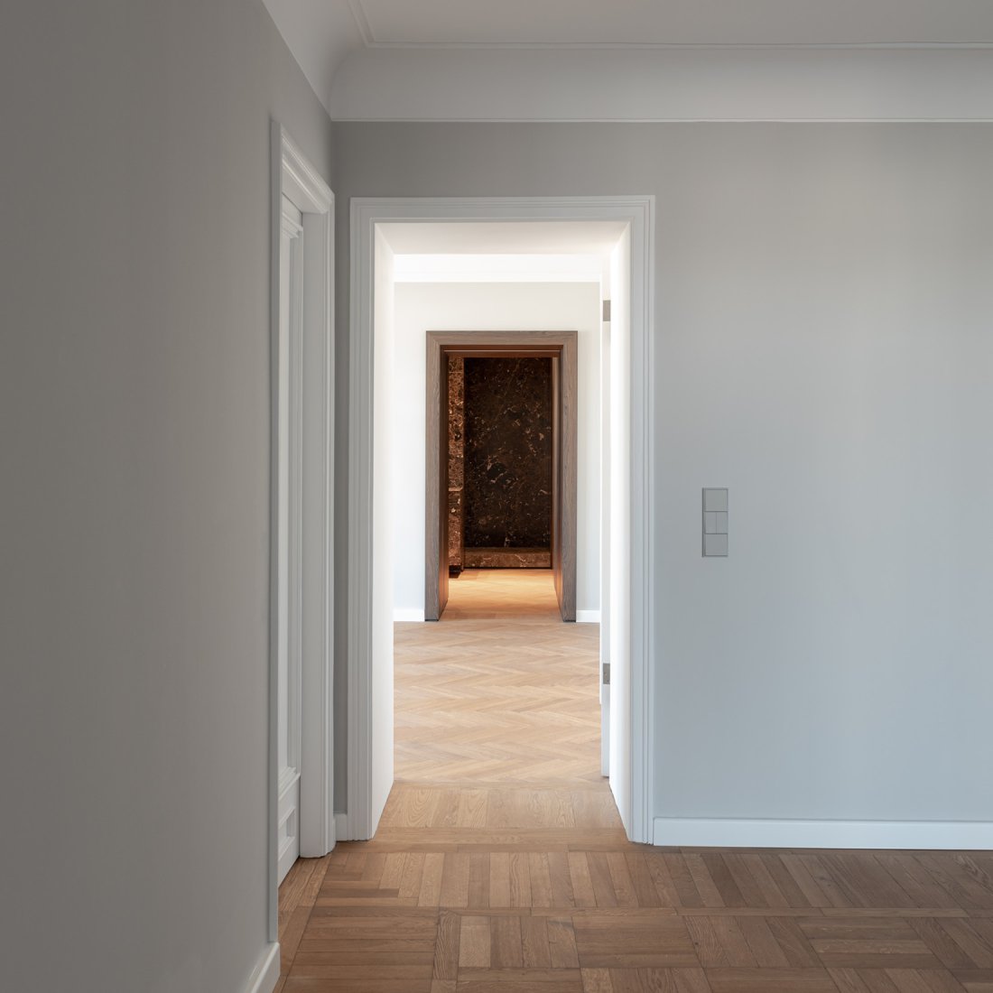 Wohndiele mit restauriertem Eichenparkett und aufgearbeiteten Bestandstüren